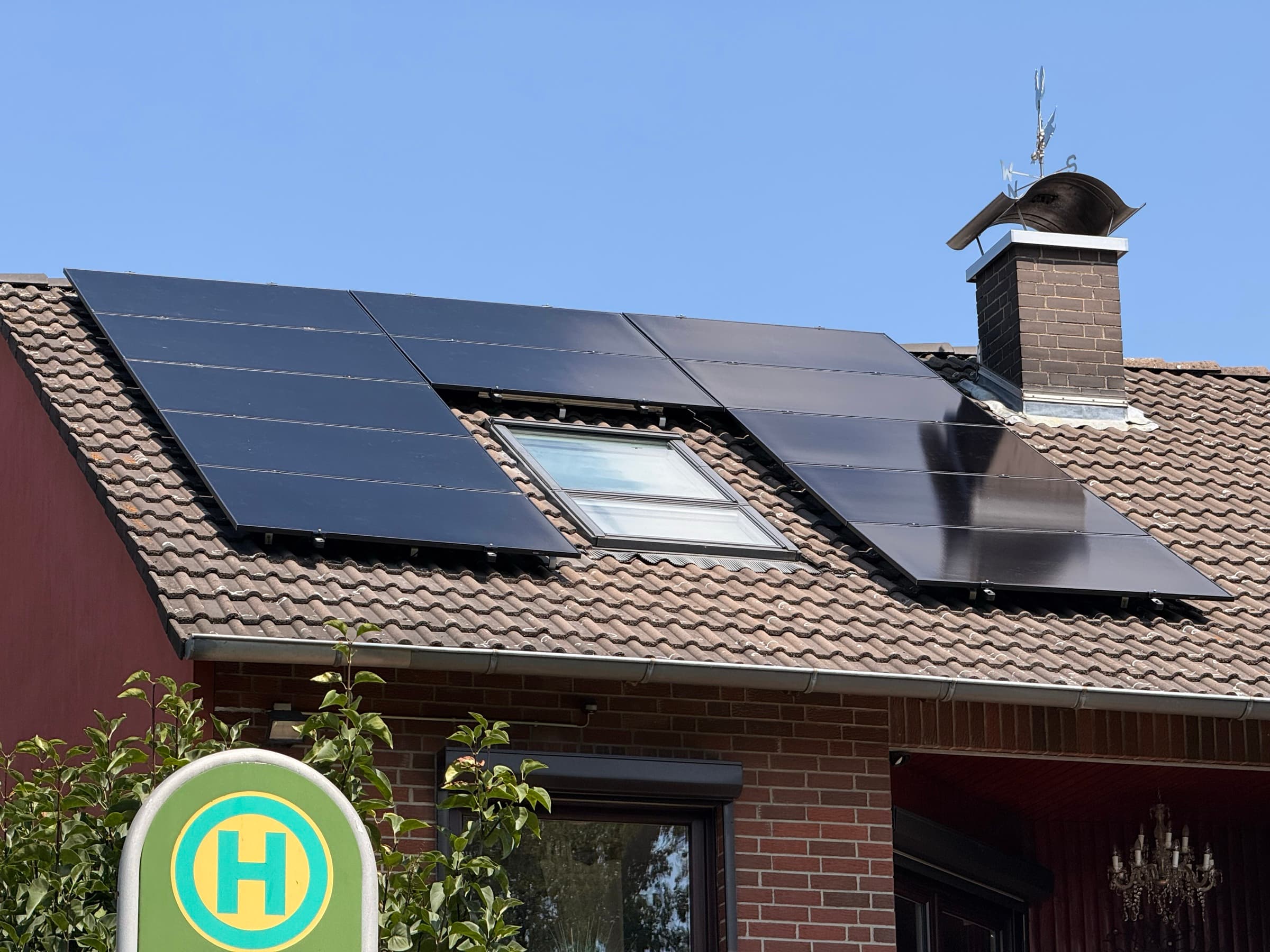 Monteur bei der Installation von Solarmodulen auf einem Ziegeldach