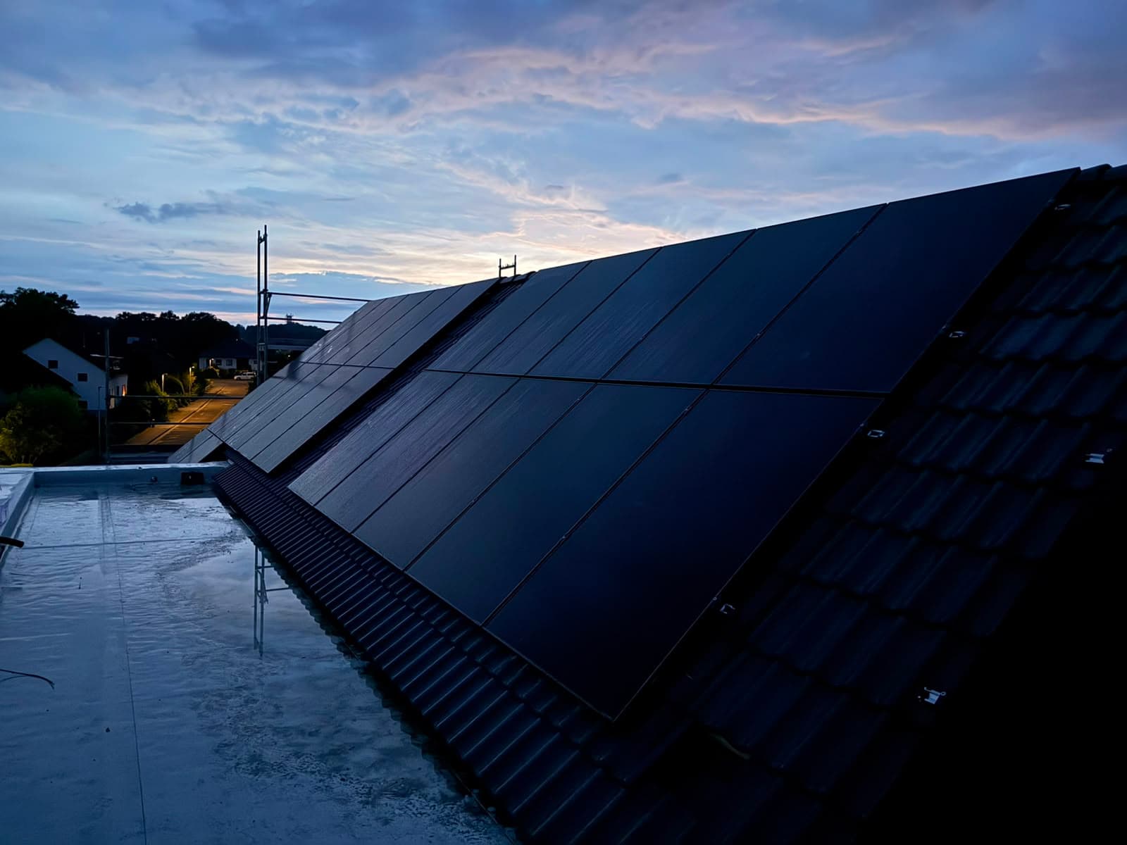 Frisch installierte PV-Module auf einem Satteldach im Abendlicht